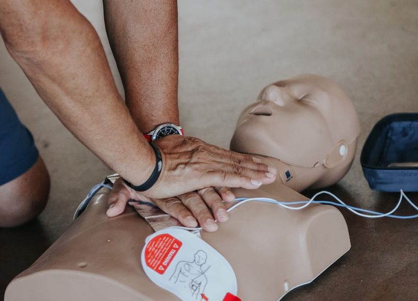 Massage cardiaque sur mannequin avec un défibrillateur de formation