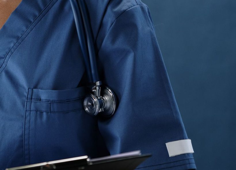 Professionnel de santé en tenue médicale bleu marine avec un stéthoscope